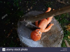 execution-murder-of-child-toy-plastic-baby-doll-with-an-ax-DHGWMH.jpg
